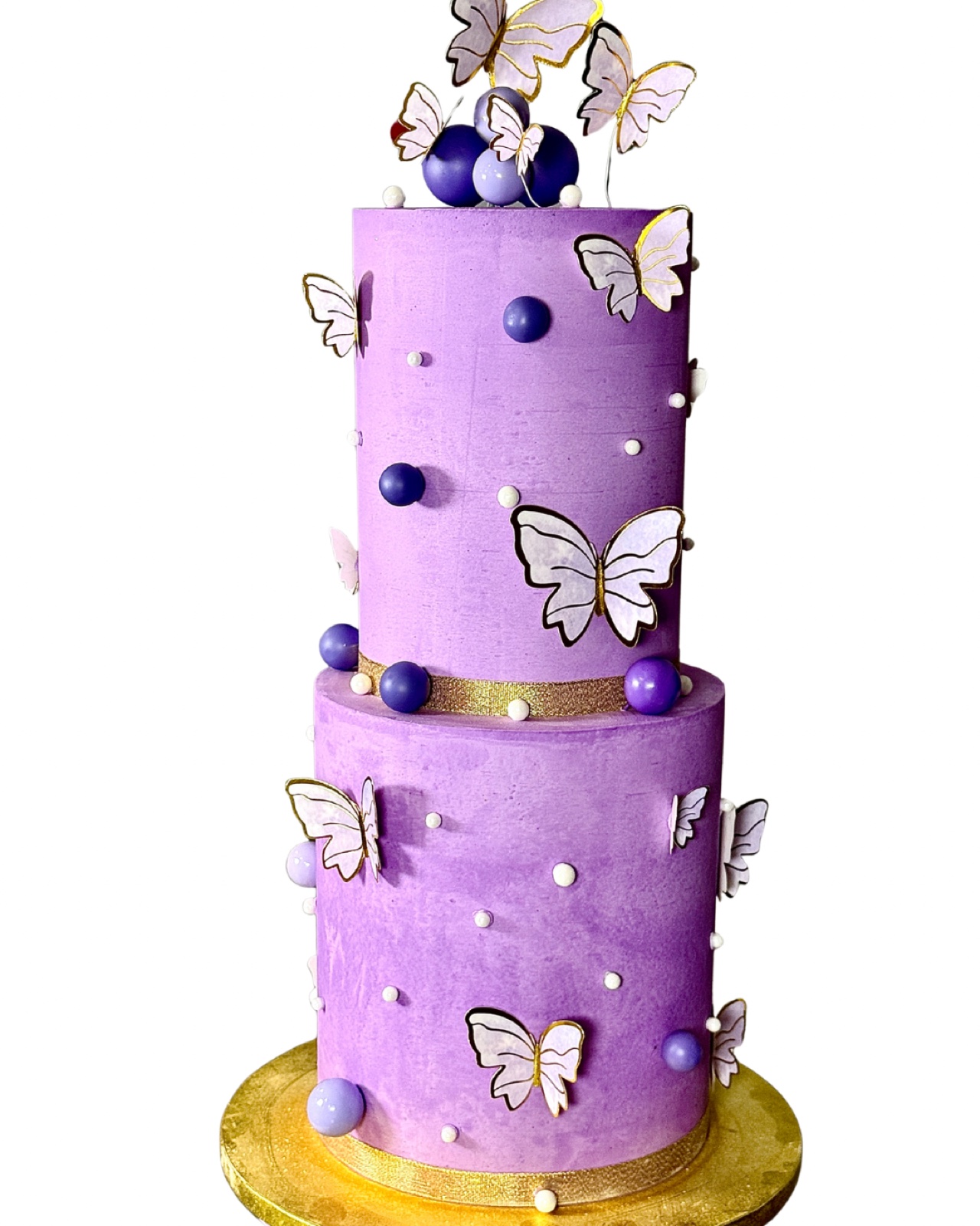 A purple two-tier cake decorated with butterflies
